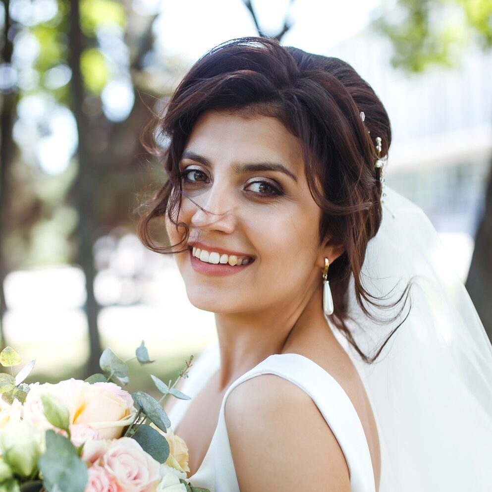 Beautiful bride with wedding bouquet for walk in park. Bride in white dress. Wedding day. Marriage.