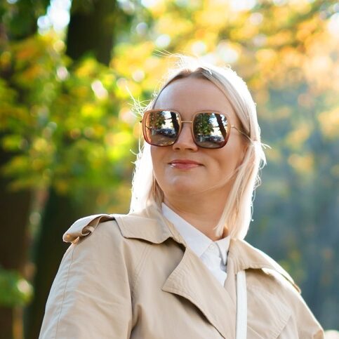 Mom with a stroller walks in the autumn park